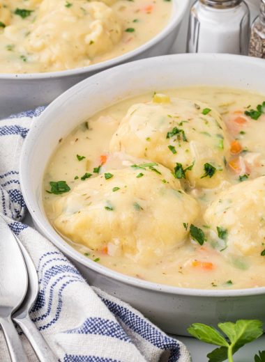 This Homemade Chicken and Dumpling soup is a flavorful, comforting soup, perfect for a rainy day or when sickness hits at home. The dumplings are like drop biscuits, they are easy to make and come together in a few minutes before cooking in the soup. My favorite thing about this soup is the delicious, thickened broth that results from the dumplings cooking in the soup. This has been a family favorite for years. Here the soup is pictured served in two soup bowls with a linen, spoons, and a spring of rosemary.