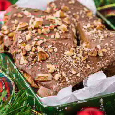 he chocolate and toffee need to set for at least 2 hours or up to overnight. You can speed up this process by placing the toffee in the fridge if desired. Place a spatula or bench scraper under the toffee and place it on a cutting board (it’s okay if it breaks a little with this process). Cut with a sharp knife to break into pieces and serve or store in an airtight container at room temperature for up to two weeks. In this image, the toffee is placed in a tin in the center of the image, surrounded by Christmas greenery, ribbon and ornaments.