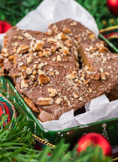 he chocolate and toffee need to set for at least 2 hours or up to overnight. You can speed up this process by placing the toffee in the fridge if desired. Place a spatula or bench scraper under the toffee and place it on a cutting board (it’s okay if it breaks a little with this process). Cut with a sharp knife to break into pieces and serve or store in an airtight container at room temperature for up to two weeks. In this image, the toffee is placed in a tin in the center of the image, surrounded by Christmas greenery, ribbon and ornaments.