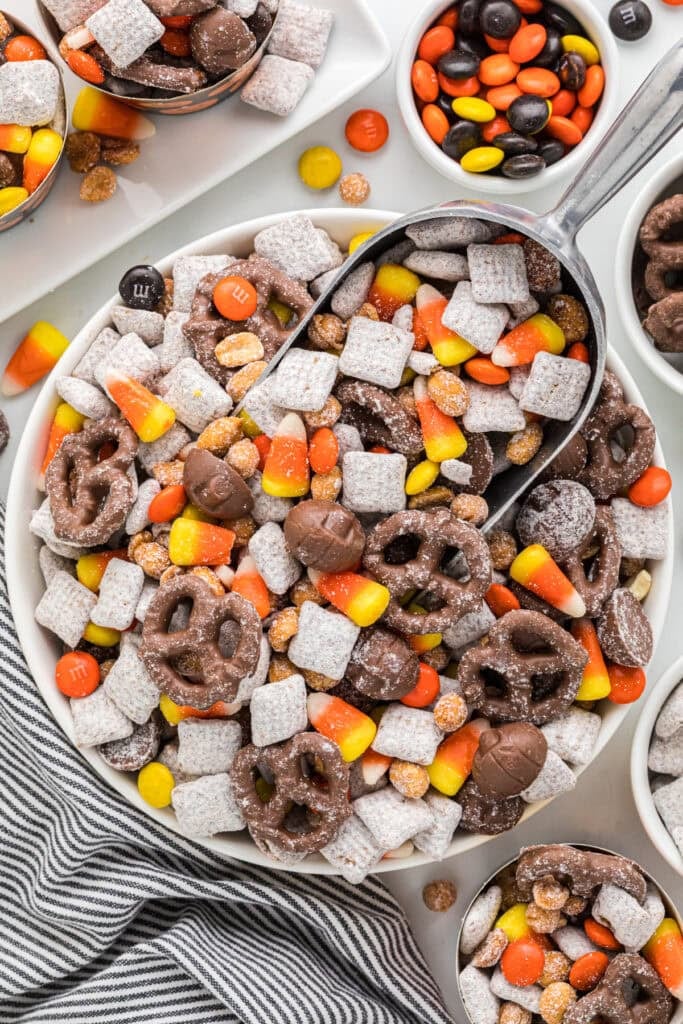 This image is an overhead shot of the snack mix being served from a bowl with little cups of the ingredients and the mix around it.